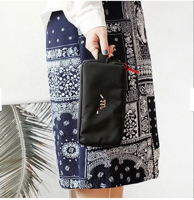 Black embroidered cosmetic travel pouch organizer bag for daily essentials.